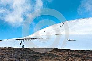 Tourists climbs for camping to the snow-capped mountain top. Con