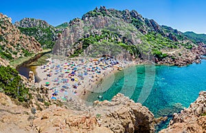 Tourists colorful sun umbrellas at Costa Paradiso Beach, Sardinia, Italy