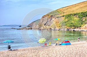 Tourists Coloured umbrellas Portwrinkle beach Whitsand Bay Cornwall England United Kingdom in colourful HDR