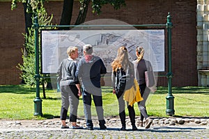 Tourists crowd around the map of the fortress on the paved area.