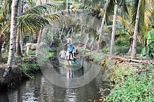 Tourists cruising on a canoe a river of the backwaters at Kollam