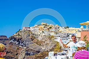 Tourists sightseeing in the incredible Fira town Santorini island Greece
