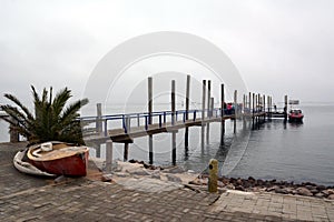 Tourists disembark from a pleasure boat on a wooden sea pier after a walk on the sea photo