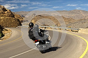 Tourists driving on a motor-bike in a curve