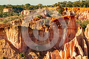 Tourists dwarfed by the rock formations at Marafa Depression - Hell's Kitchen at sunset in Malindi, Kenya