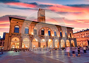 Tourists enjoing beautiful summer evening on main square of City of Bologna with popular historical place - Palazzo Re Enzo.