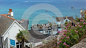 Tourists enjoy the pub on the seafront of the fishing village of St. Ives on the coast of North Cornwall, England August