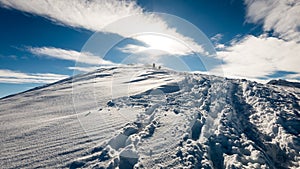 Turisti, ktorí si užívajú vysoké hory v snehu za slnečného dňa