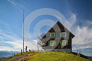 Tourists enjoying small break close to wooden house under Chli Aubrig peak