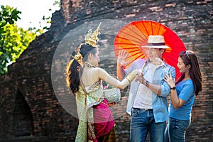 Tourists are enjoying the Songkran Festival. Thai girls and Young caucasian man splashing water during festival Songkran.