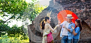 Tourists are enjoying the Songkran Festival. Thai girls and Young caucasian man splashing water during festival Songkran.