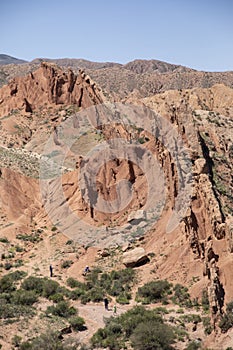 Tourists explore the dramatic landscape of the Fairy Tale Canyon, or Skazka Canyon in Kyrgyzstan