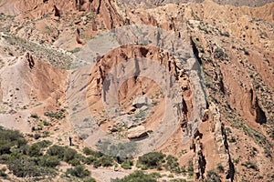 Tourists explore the dramatic landscape of the Fairy Tale Canyon, or Skazka Canyon in Kyrgyzstan