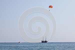 Tourists fly over the sea and the beach on a parachute. Sport and recreation for tourists in turkey