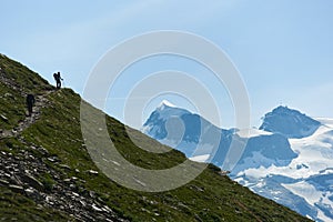 Tourists following path in mountains.