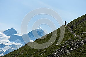 Tourists following path in mountains.