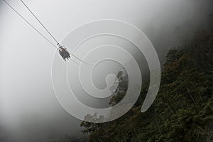 Tourists gliding on the zip line to a mountain