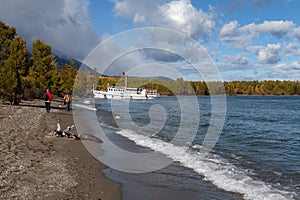 Tourists going along the coastline to the ship