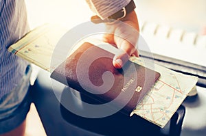 Tourists handle passports and suitcases to prepare for the trip.