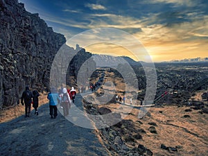 Tourists or hikers walking along country road in Iceland