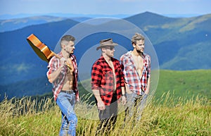 Tourists hiking concept. Hiking with friends. Long route. Adventurers squad. Group of young people in checkered shirts