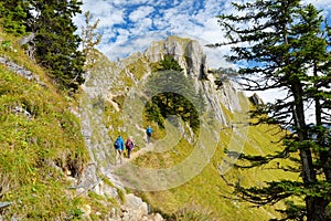 Tourists on a hiking trails of picturesque Tegelberg mountain, a part of Ammergau Alps, located nead Fussen town, Germany.