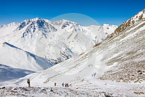 Tourists hiking in winter mountains in Kazakhstan.