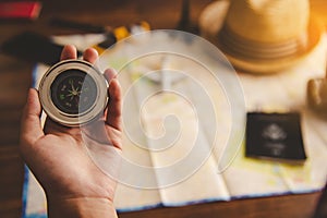 Tourists hold a compass and locate a place on a world map