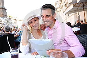 Tourists holding tablet at cafe in Rome