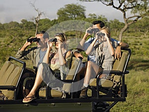 Tourists In Jeep Looking Through Binoculars