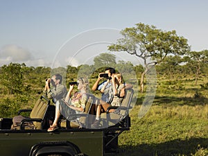 Tourists In Jeep Looking Through Binoculars