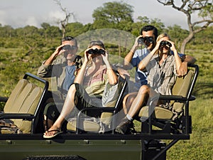 Tourists In Jeep Looking Through Binoculars
