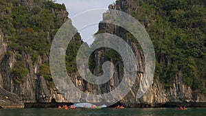 Tourists in kayaks or canoes exploring the caves and limestone islands of Ha Long Bay, Vietnam