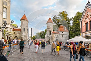 Tourists leave the medieval Old Town of Tallinn Estonia through the picturesque Viru Gate
