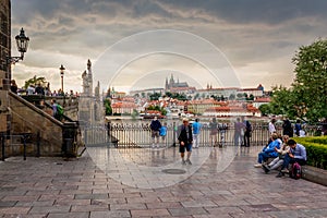 Tourists looking at the Charles Bridge and Prague Castle in Prague during Sunset, Czech Republic.