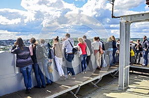 Tourists looking on a cityscape on a top Clock Tower of City Hall on the historic part of Lviv, Ukraine