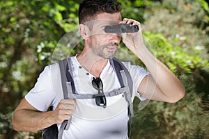 tourists man with binoculars looking for something