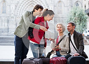 Tourists with map and baggage in city