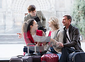 Tourists with map and baggage in city