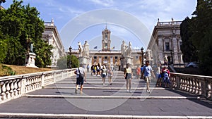 Tourists on Michelangelo stairs to Piazza del Campidoglio on top of Capitoline Hill and Palazzo Senatorio, Rome, Italy