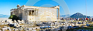 Tourists near Erechtheum temple ruins in Acropolis, Athens banner background