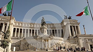 Tourists near the Monument to Victor Emmanuel II. Italy flags near the monument to Victor Emmanuel fluttering in the