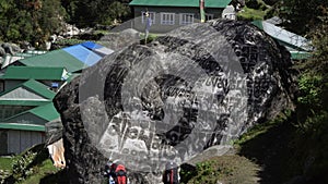 Tourists are near prayer stone in Nepal