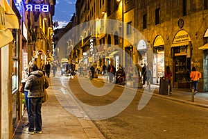 Tourists near shops on via Guicciardini in evening