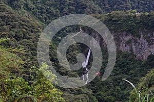 Tourists at the Pailon del Diablo waterfall in BaÃÂ±os, Ecuador photo