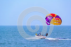 Tourists parasailing on Candolim Beach in Goa, India.