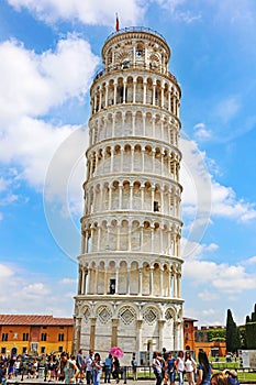 Tourists posing in front of the leaning Pisa tower in Italy - one of the most famous italian landmarks