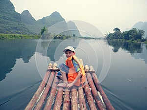 Tourists rafting along the Yangshuo River, a raft boy