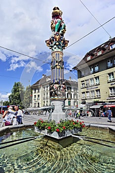 Tourists reading map at water well, Bern, Switzerland