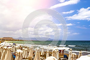 Tourists relaxing on Beach with views along coastline, Crete, Greece, Europe
